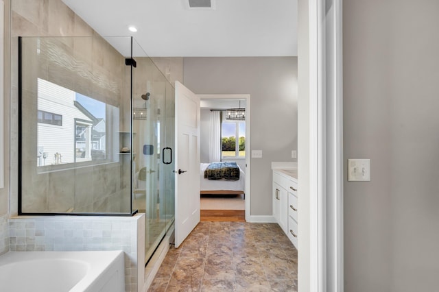 full bathroom featuring a shower stall, a garden tub, vanity, and ensuite bathroom