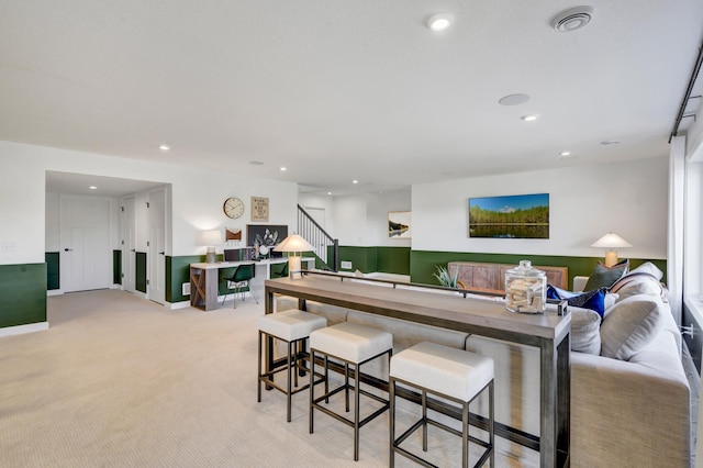living area with recessed lighting, stairway, and light carpet