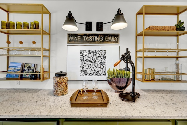 interior space with open shelves, light stone countertops, and green cabinets