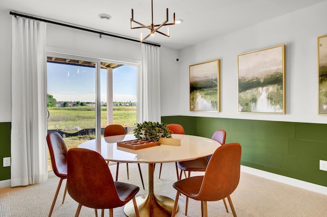 dining room with carpet floors, a chandelier, and baseboards