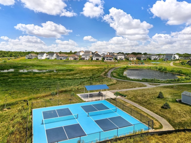 view of community featuring fence, a water view, a residential view, and a tennis court