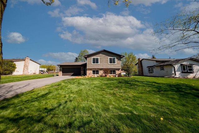 view of front of house with a garage, brick siding, a front yard, and aphalt driveway