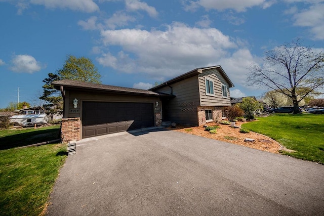 view of side of property featuring a garage, driveway, brick siding, and a lawn