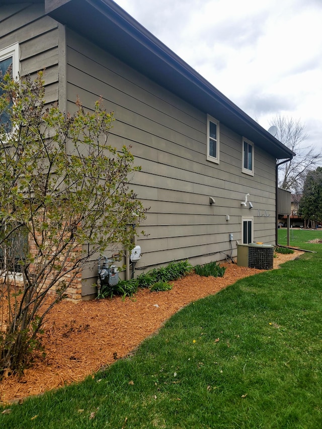 view of home's exterior with a yard and central AC