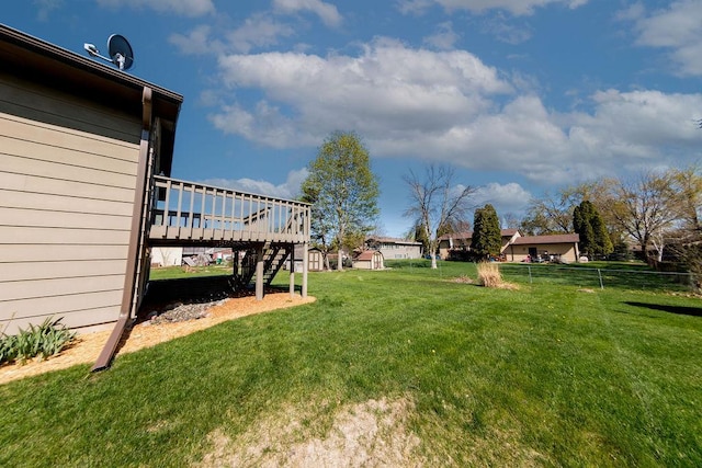 view of yard with fence, stairway, and a deck