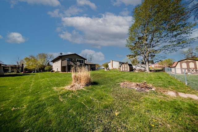 view of yard featuring a storage shed, an outdoor structure, and fence