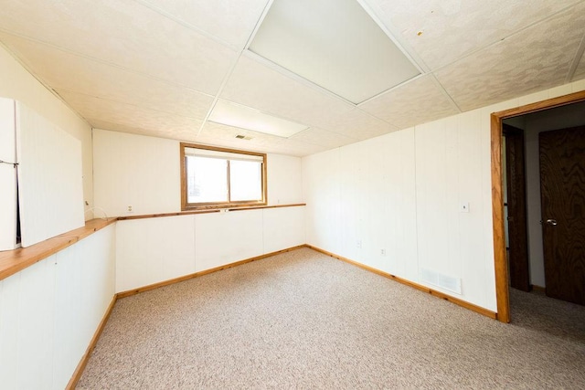 empty room featuring baseboards and light carpet
