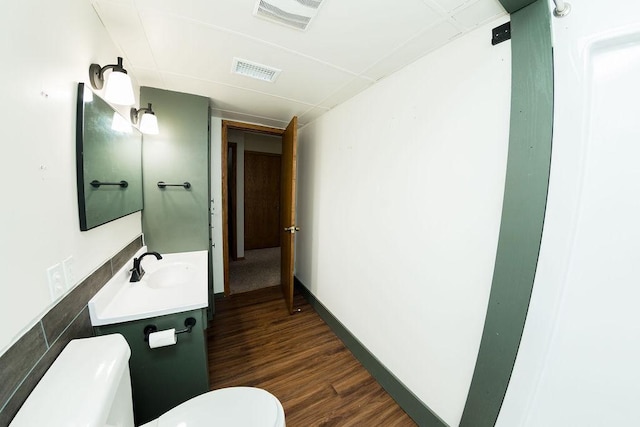 bathroom featuring vanity, toilet, visible vents, and wood finished floors