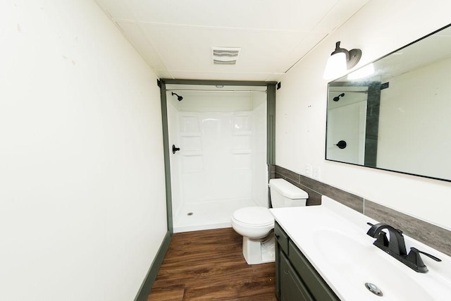 full bath featuring toilet, wood finished floors, tile walls, a shower stall, and vanity