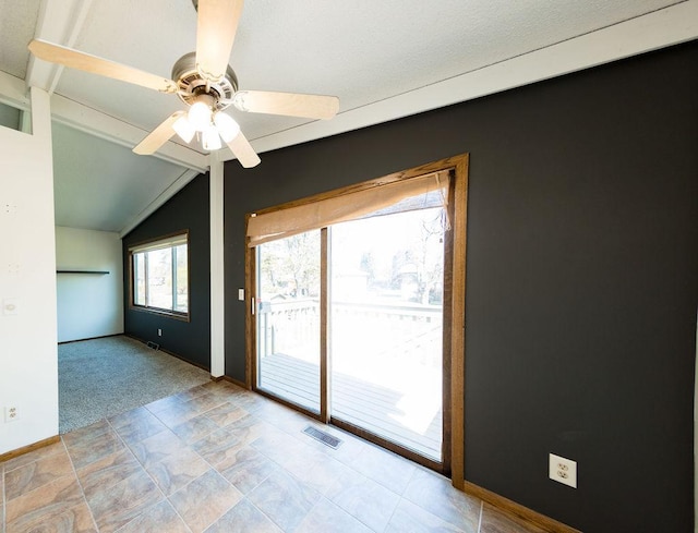 spare room with visible vents, baseboards, ceiling fan, and vaulted ceiling with beams