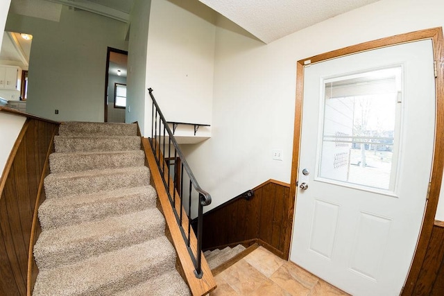 staircase with wooden walls and wainscoting