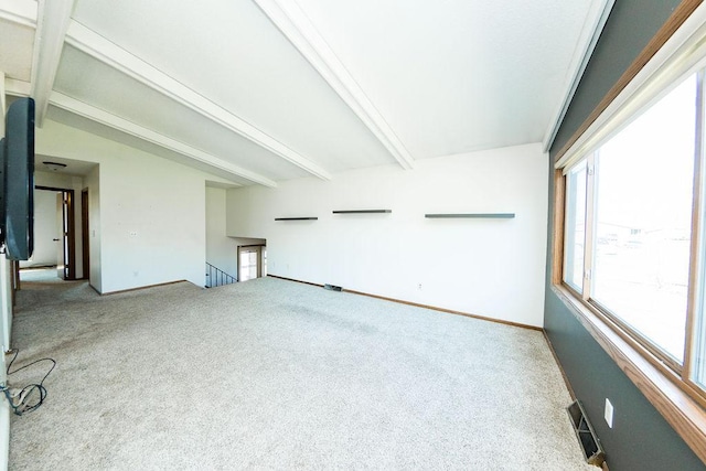 unfurnished living room featuring carpet, beamed ceiling, baseboards, and visible vents