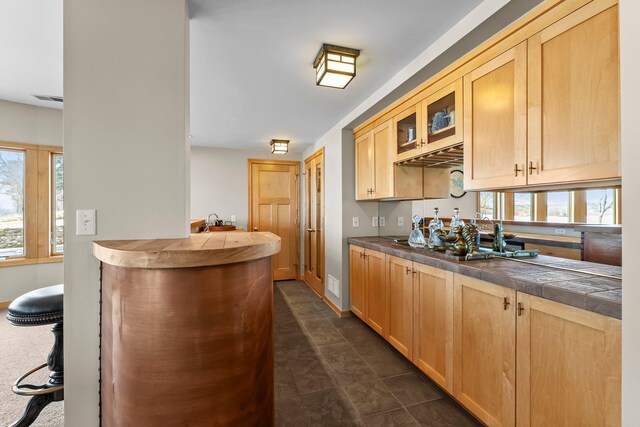 2625 Woodbridge Rd, Minnetonka Beach, MN 55391 - kitchen with glass insert cabinets, light brown cabinets, healthy amount of natural light, and tile counters