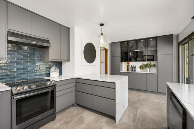 kitchen featuring stainless steel range with electric cooktop, gray cabinets, a peninsula, tasteful backsplash, and under cabinet range hood