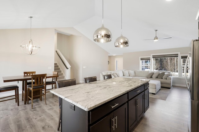 24235 143rd St NW, Zimmerman, MN 55398 - kitchen with lofted ceiling, freestanding refrigerator, open floor plan, ceiling fan, and a chandelier