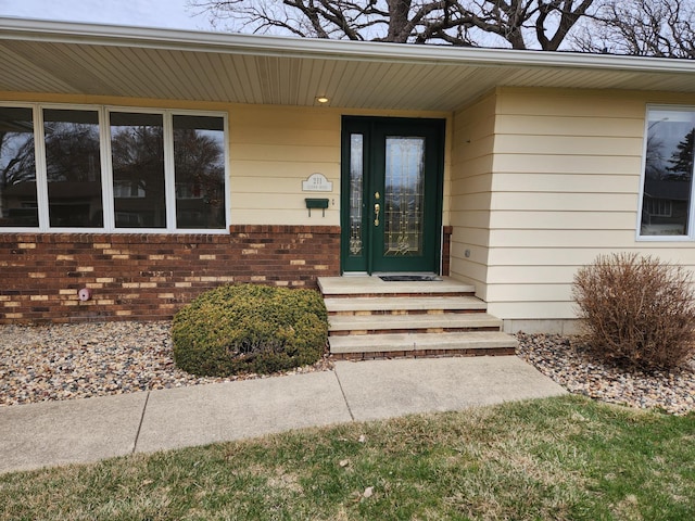 view of exterior entry featuring brick siding