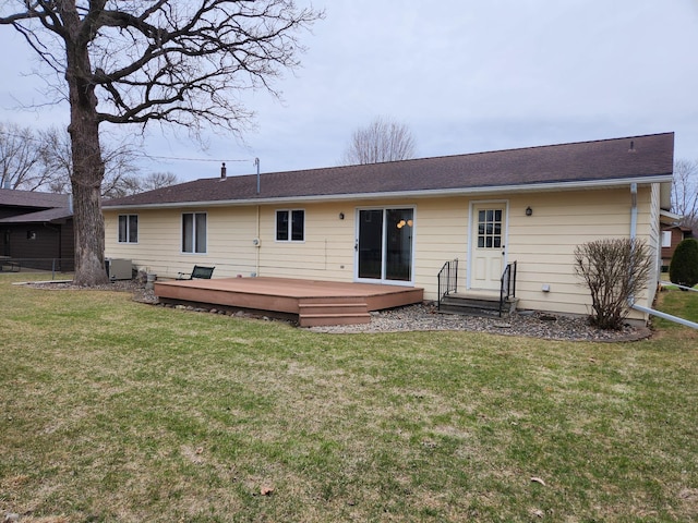 rear view of house with central air condition unit, a wooden deck, and a lawn