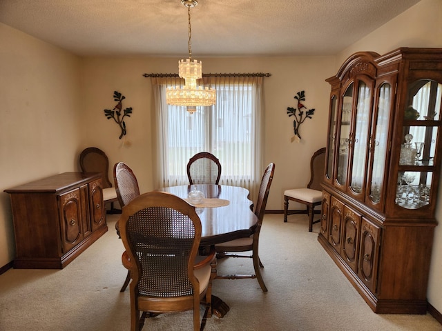 dining area with baseboards, a notable chandelier, light colored carpet, and a textured ceiling