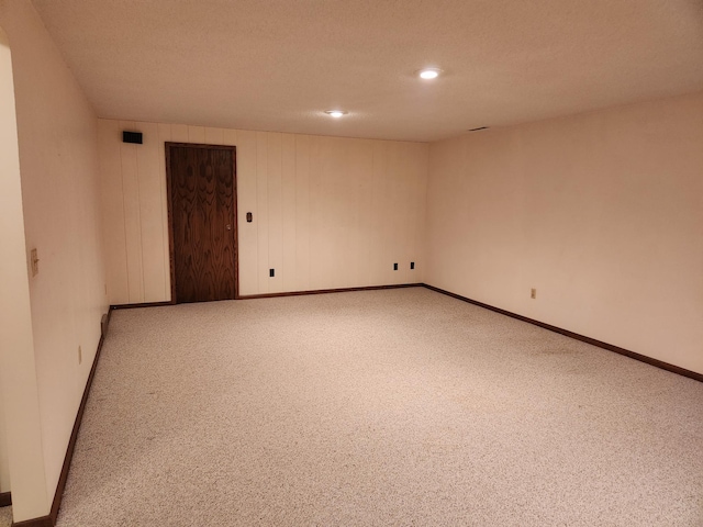 carpeted spare room with a textured ceiling, baseboards, and recessed lighting