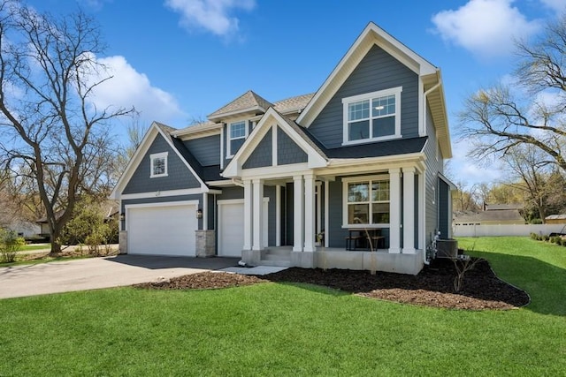 view of front facade with a porch, driveway, roof with shingles, a front yard, and a garage