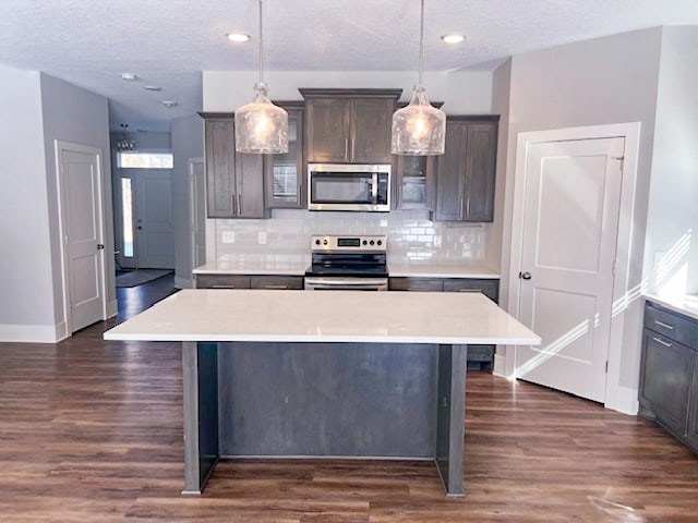 13357 Two Mile Rd, Brainerd, MN 56401 - kitchen featuring appliances with stainless steel finishes, tasteful backsplash, light countertops, dark wood-style floors, and a textured ceiling