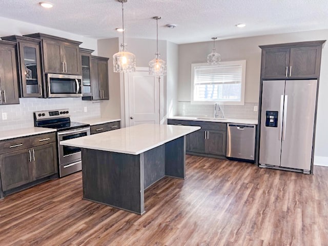 13357 Two Mile Rd, Brainerd, MN 56401 - kitchen with appliances with stainless steel finishes, a sink, dark wood-style flooring, glass insert cabinets, and light countertops