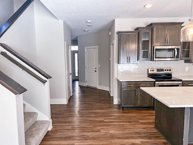 13357 Two Mile Rd, Brainerd, MN 56401 - kitchen featuring appliances with stainless steel finishes, light countertops, dark wood-style floors, decorative backsplash, and glass insert cabinets
