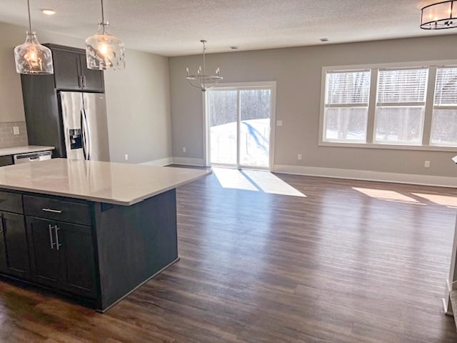 13357 Two Mile Rd, Brainerd, MN 56401 - kitchen featuring stainless steel refrigerator with ice dispenser, a chandelier, dark wood-type flooring, open floor plan, and light countertops