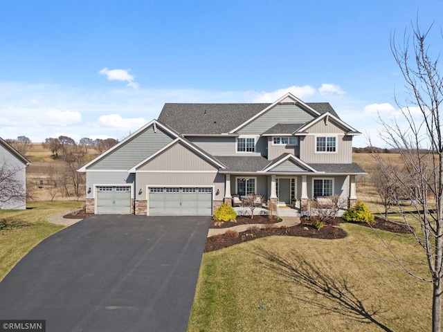 craftsman house featuring stone siding, a garage, aphalt driveway, a front lawn, and roof with shingles