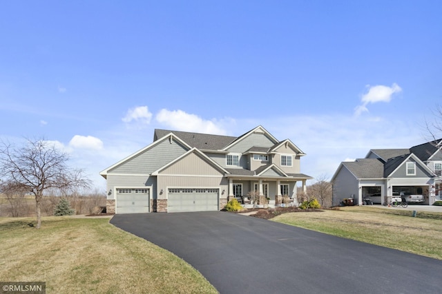 craftsman-style home featuring stone siding, an attached garage, aphalt driveway, a porch, and a front yard