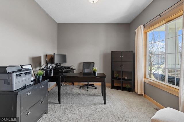 office with baseboards and light carpet