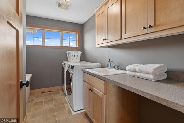 clothes washing area featuring cabinet space, visible vents, washing machine and clothes dryer, and a sink