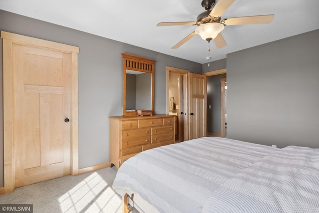 bedroom with light colored carpet, baseboards, and ceiling fan