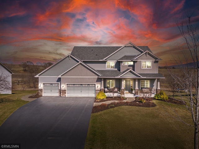 craftsman-style house featuring aphalt driveway, a lawn, stone siding, an attached garage, and a shingled roof