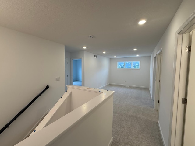corridor with light colored carpet, recessed lighting, an upstairs landing, and baseboards