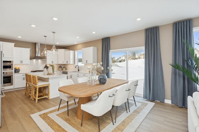 dining space with light wood-style floors and recessed lighting