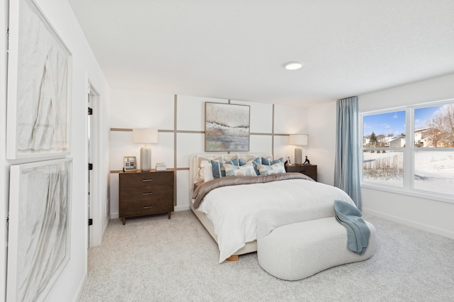 bedroom featuring light colored carpet and baseboards