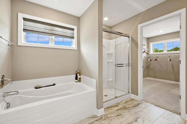 bathroom featuring a shower stall, a garden tub, marble look tiles, and baseboards