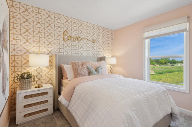 bedroom with carpet flooring, an accent wall, baseboards, and wallpapered walls
