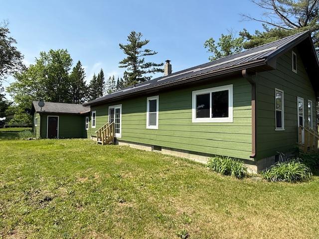 39698 10th Ave, Isle, MN 56342 - back of property featuring entry steps, a lawn, crawl space, and a metal roof