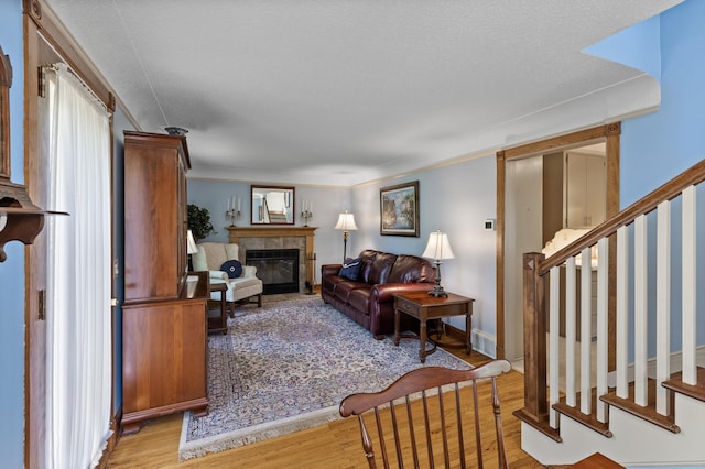 3021 Atwater St, Hopkins, MN 55305 - living area with a tiled fireplace, wood finished floors, stairs, and crown molding