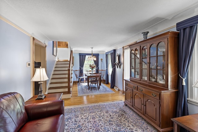 3021 Atwater St, Hopkins, MN 55305 - living area featuring light wood-style flooring, stairs, a chandelier, and crown molding