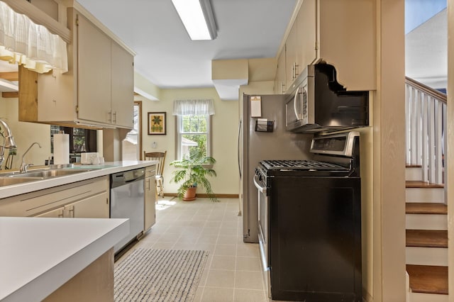 3021 Atwater St, Hopkins, MN 55305 - kitchen featuring stainless steel appliances, light countertops, a sink, cream cabinetry, and baseboards