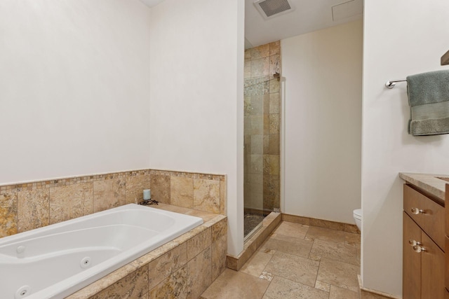 bathroom with toilet, stone tile floors, a shower stall, a jetted tub, and vanity