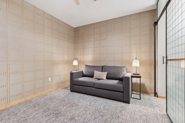 sitting room featuring carpet and baseboards