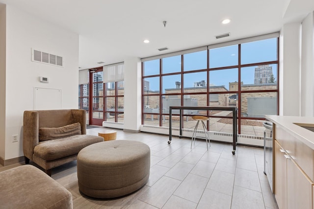 living area featuring expansive windows, plenty of natural light, recessed lighting, and a city view
