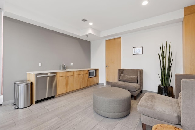 bar area featuring stainless steel dishwasher, recessed lighting, baseboards, a sink, and a tray ceiling