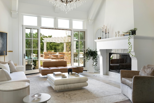 living area with a high ceiling, a notable chandelier, and a fireplace