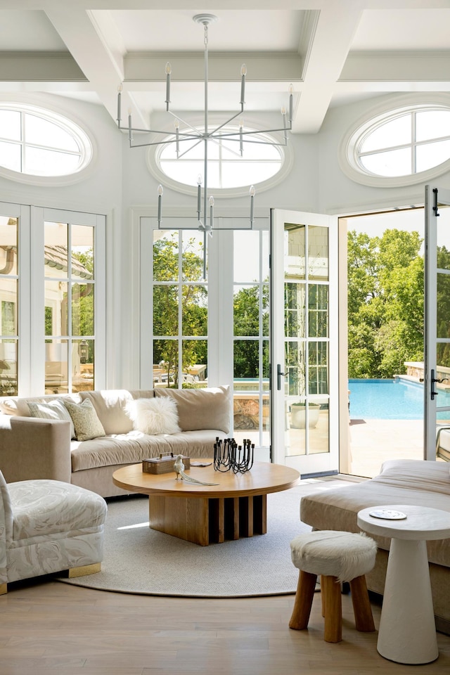 sunroom with coffered ceiling, french doors, beamed ceiling, and a notable chandelier