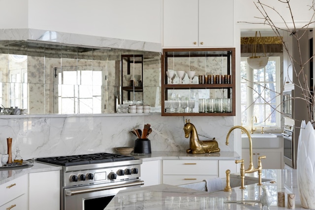 kitchen featuring decorative backsplash, white cabinets, and stainless steel appliances